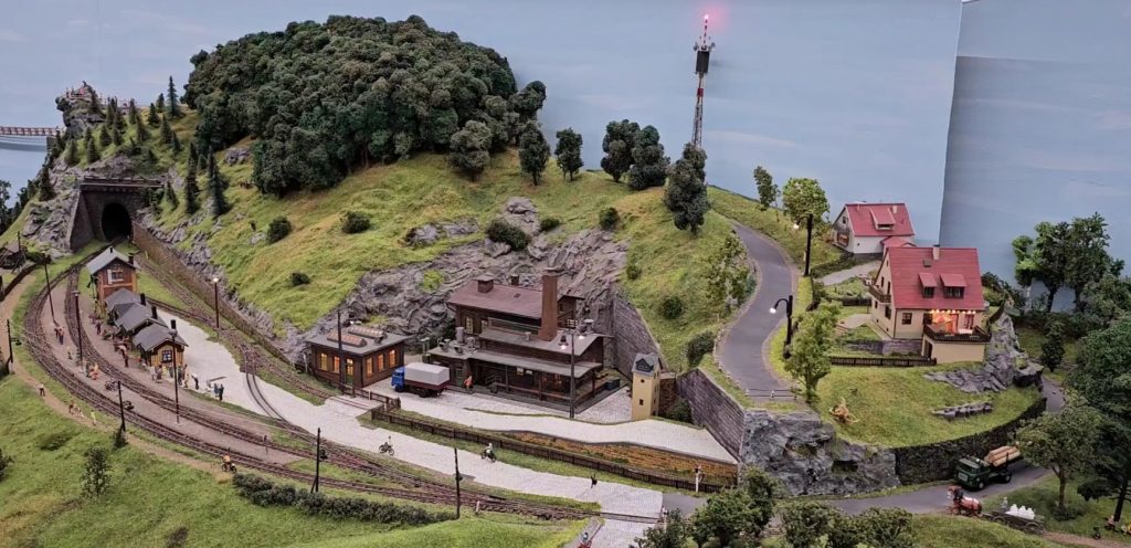 Auf diesem Bild ist das Modell einer Glockengießerei und zwei Einfamilienhäuser bei Tag zu sehen.